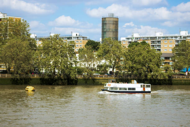 Thames riverside view in London with a boat going by and blue skies