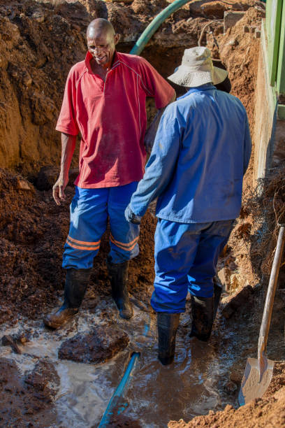 istock african american plumber construction workers fixing a blocked drainage pipe in the trench outdoors 2177142078
