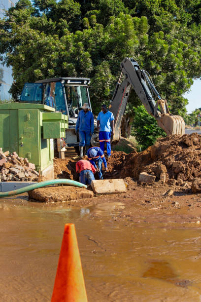 istock african american construction workers with an excavator fixing a blocked damaged broken drainage pipe in the trench outdoors 2177142305