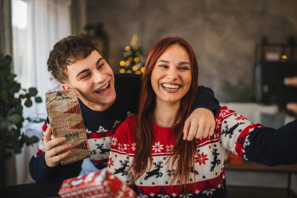 istock young couple take a self portrait on mobile phone with christmas gift 2177147454