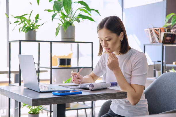istock Female college student studying using laptop, sitting in coworking cafe 2177148909