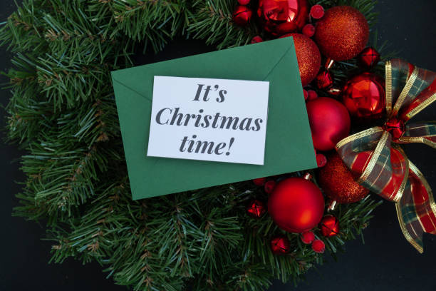 istock IT'S CHRISTMAS TIME text on postcard with green envelope on handmade Christmas wreath. Zero waste eco-friendly Christmas. Sustainable greeting card 2177152188