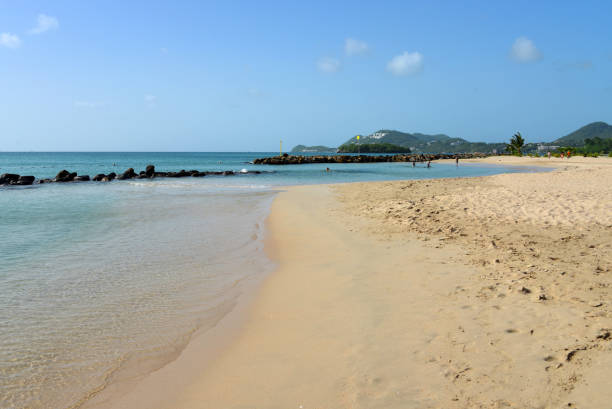 Castries, Saint Lucia, West Indies: Vigie Beach is a popular beach located just north of Castries, Saint Lucia, near the Vigie Peninsula. Known for its long stretch of golden sand and calm, clear waters, it is a favorite spot for both locals and visitors looking to relax or enjoy water activities. The beach is easily accessible, lying close to George F. L. Charles Airport and just a short drive from downtown Castries. Despite its proximity to the city, Vigie Beach maintains a peaceful atmosphere, with minimal commercialization, making it ideal for leisurely walks, swimming, or picnics. Its scenic views and calm surf make it a key destination in Castries.