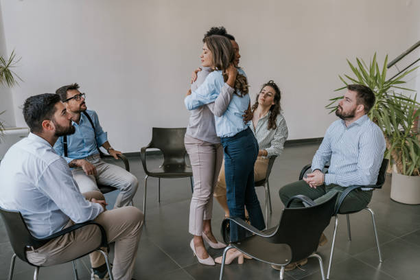 istock Group psychotherapy session with two women embracing in modern office setting 2177153395