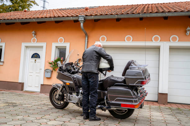 istock Elderly Man with Touring Motorcycle in Driveway 2177154321