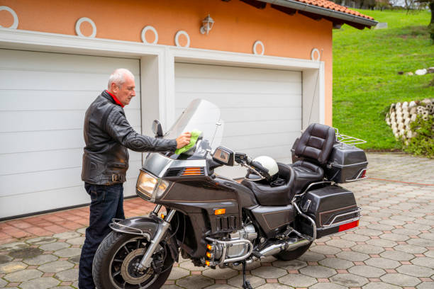 istock Man Cleaning Motorcycle in Garage 2177154324