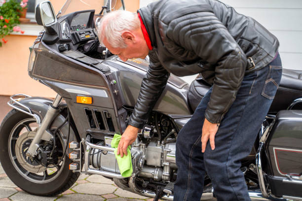 istock Man Cleaning Motorcycle in Garage 2177154326