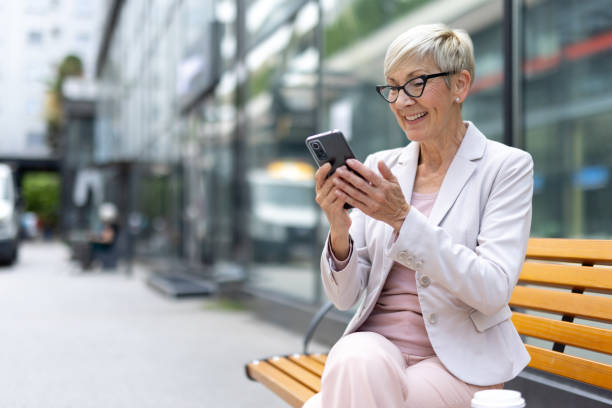 istock Woman on bench engaged with her mobile phone 2177155082