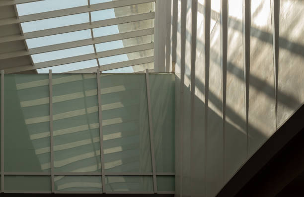 Bangkok, Thailand - 28 Sep, 2024 - Modern architecture interior design of metal structure building with Burred light and shadow passing through glazed ceiling. Abstract image of Sunlight shining through a glass roof and creating shadows on a wall, Copy space, Selective focus.