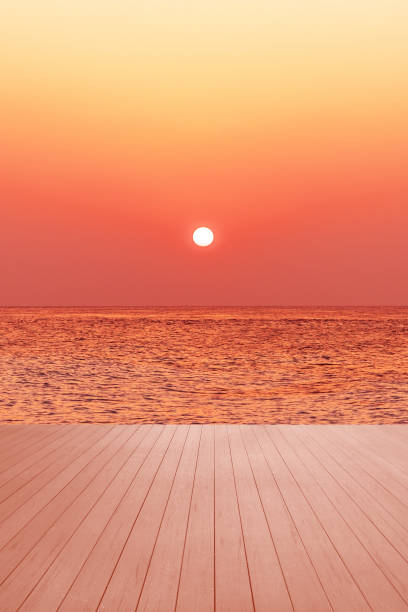 Empty wooden terrace and sea with dramatic sky during sunset