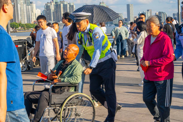 Shanghai, China - October 3rd 2024: tourists and locals enjoy a sunny day on The Bund, a scenic waterfront area in central Shanghai. It is one of the most famous tourist destinations in Shanghai and houses buildings of various architectures.