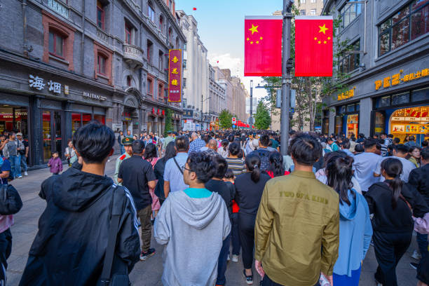 Shanghai, China - October 3rd 2024: Crowds walk on Nanjing Road at sunny day. The street is the main shopping district of the city and one of the world's busiest shopping districts.