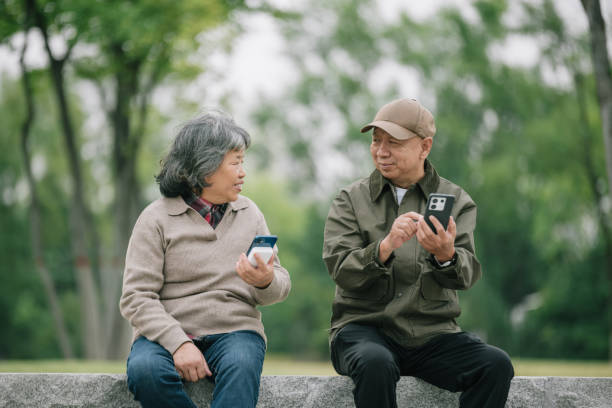 Elder couple use smart phone in the park