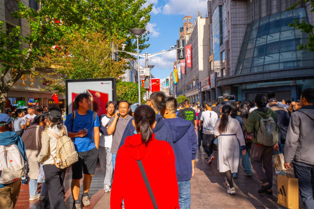Shanghai, China - October 3rd 2024: Crowds walk on Nanjing Road at sunny day. The street is the main shopping district of the city and one of the world's busiest shopping districts.