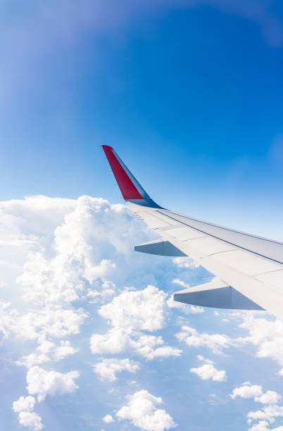 istock View from the airplane window at a beautiful cloudy sky and the airplane wing 2177168315