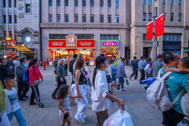 Shanghai, China - October 3rd 2024: Crowds walk on Nanjing Road at sunny day. The street is the main shopping district of the city and one of the world's busiest shopping districts.