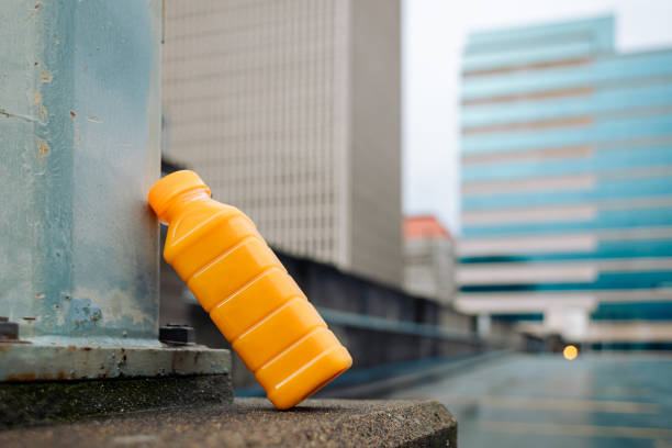 Recyclable transparent PET (polyethylene terephthalate) bottle with fruit juice drink. City shown in background with copy space.