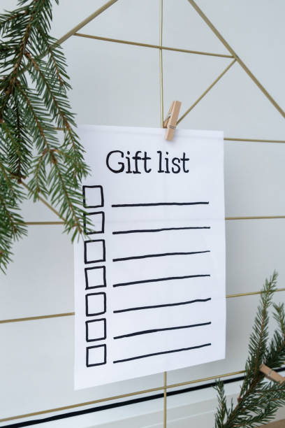 Holiday preparation paper note with GIFT LIST checklist text. Vision board with cozy minimalistic handmade new year Christmas decor Low key festive celebration