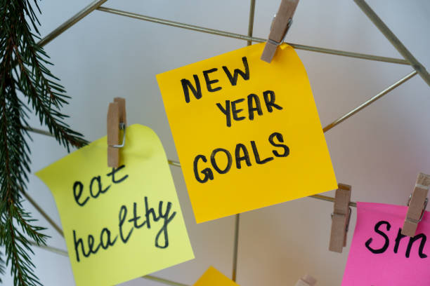 istock Action board new year's resolutions on colorful sticky notes. Making promises for new year, setting goals. Dream year 2177176981