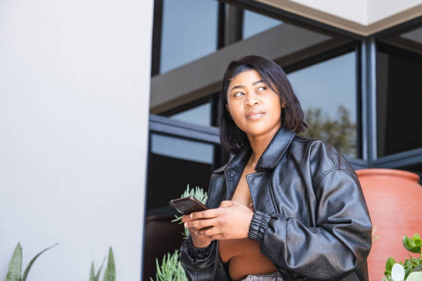 istock African woman using her mobile phone to make a payment 2177178747