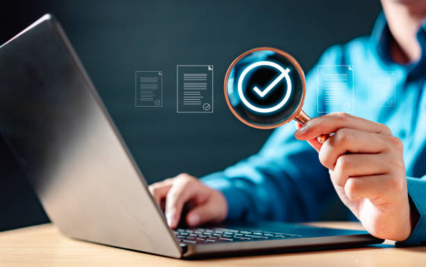istock A person is holding a magnifying glass over a laptop screen. 2177180870