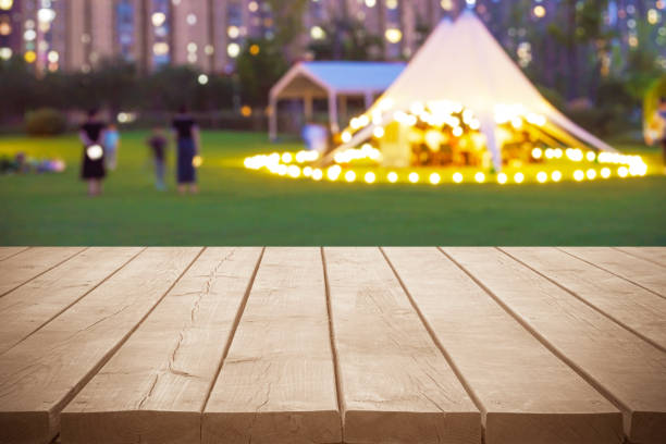 Empty wooden table top with dusk tent camping blurred abstract scenes