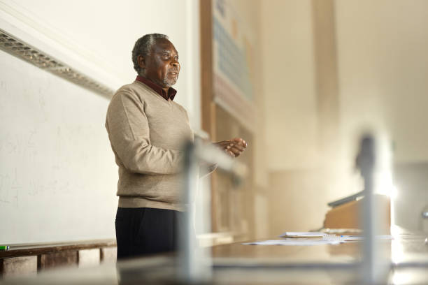 African American male teacher talking about lecture during a class at lecture hall. Copy space.