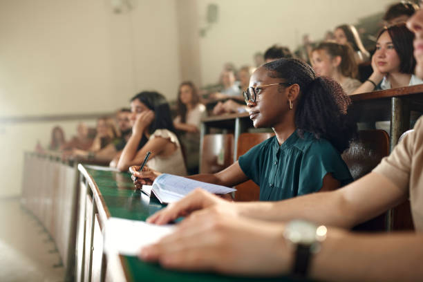 istock Black female student attending a class with her friends at lecture hall. 2177186672