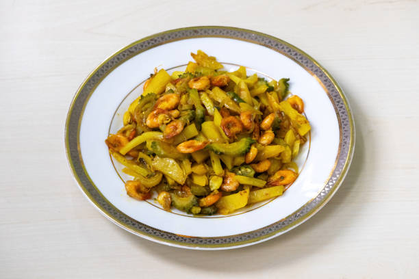 istock Bitter gourd, potatoes, and fried prawns mixed together and cooked, served on a white plate. It is very healthy and delicious vegetable dish. 2177186738