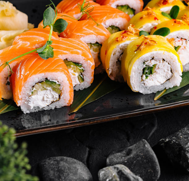 istock Fresh sushi rolls presenting salmon and cream cheese filling on black plate 2177188422