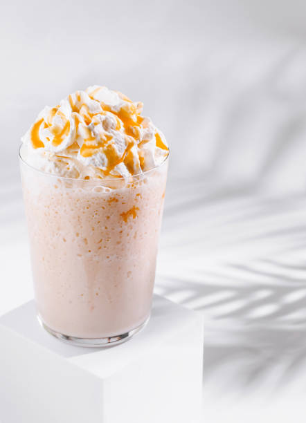 istock Caramel milkshake with whipped cream standing on white cube 2177189731