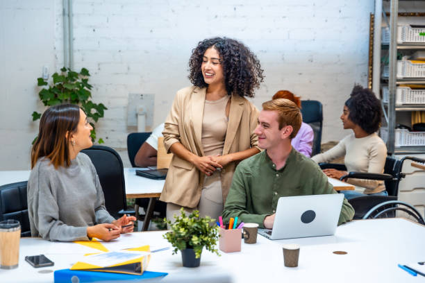 Three coworkers talking distracted in a modern room