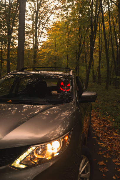 istock Autumn SUV with Driver with Pumpkin Head in Forest 2177190848