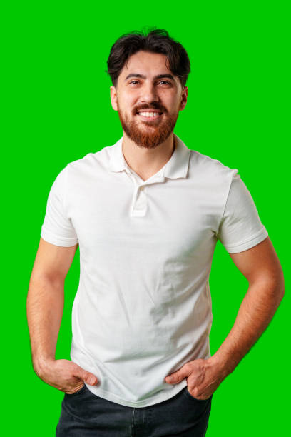 istock A smiling young man with a beard poses against a bright green background 2177190944