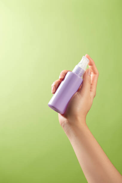 istock The image used as a template for product advertisements shows a serene green background with a woman hand delicately grasping a unlabeled purple spray bottle, sample image for skincare advertisement 2177192015