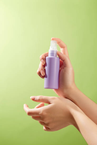 istock The image is perfect for promoting skincare items since a hand tenderly administers a purple spray lotion to the skin, showing its moisturizing qualities against a green backdrop. 2177192017