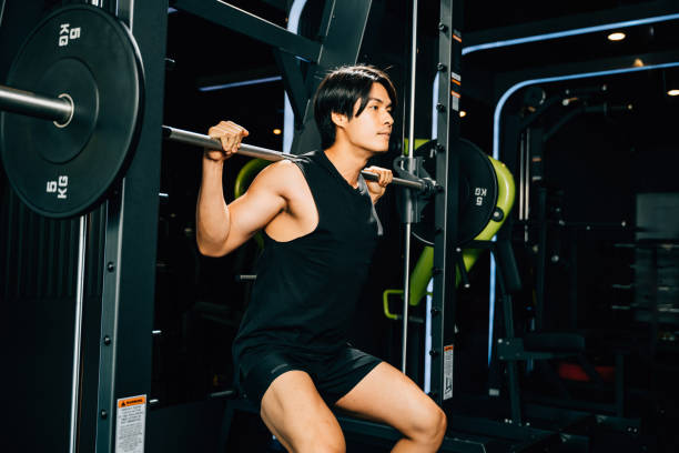 istock Asian muscular man guy performing a squat exercise legs heavy weights with a barbell in gym, men doing lifting barbell work out at fitness gym, sport workout healthy lifestyle 2177193742