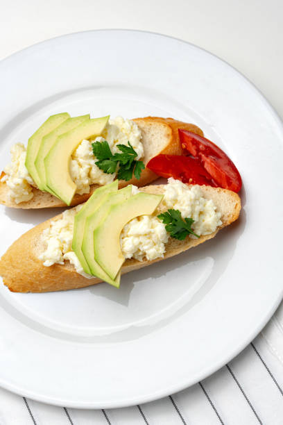 istock Fresh avocado and cheese spread on toasted bread garnished with cilantro and tomato 2177194149