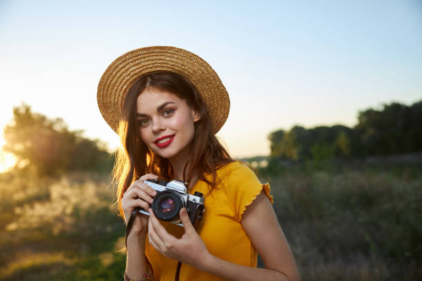 istock pretty woman holding camera smile red lips hat nature 2177195625