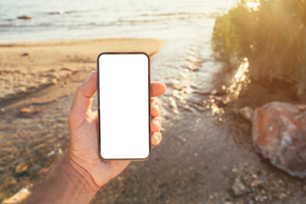 istock Smartphone mockup, man holding mobile phone with blank white screen outside at seaside landscape in morning 2177196226