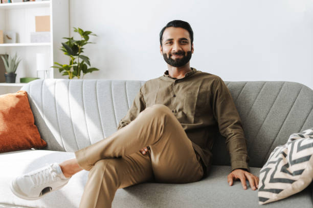 istock Confident entrepreneur, smiling Indian man sitting on sofa at home, looking at camera 2177197094