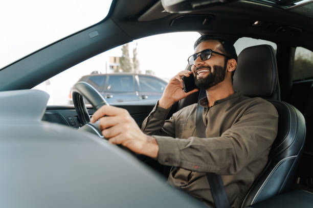 istock Modern Indian businessman talking on mobile phone while driving modern car 2177197149
