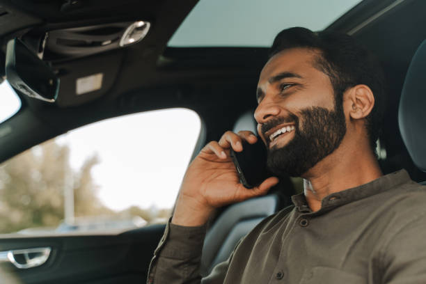 istock Smiling, handsome Indian businessman talking on the phone while driving car 2177197159