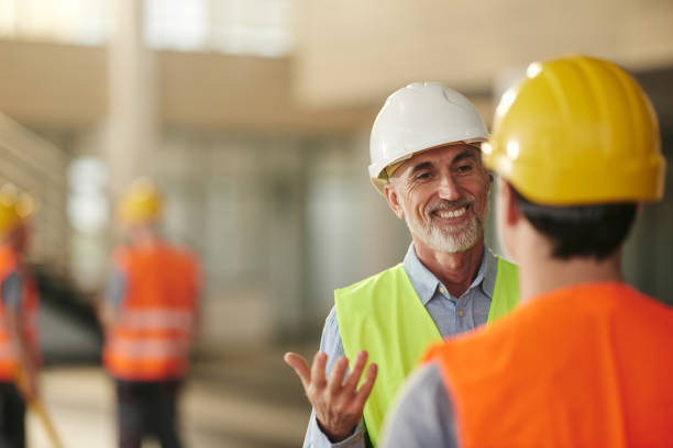 istock Happy male architect talking to his worker at construction site. 2177198148