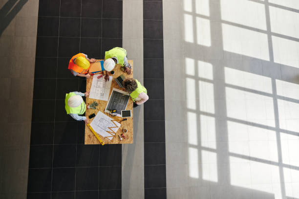 istock Above view of construction team working on project plans. 2177198404