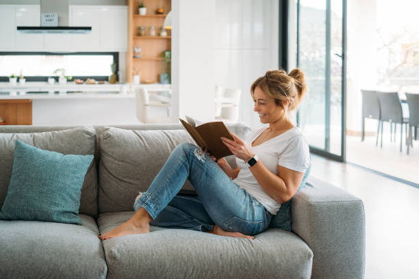 istock Blonde woman reading on sofa 2177202045