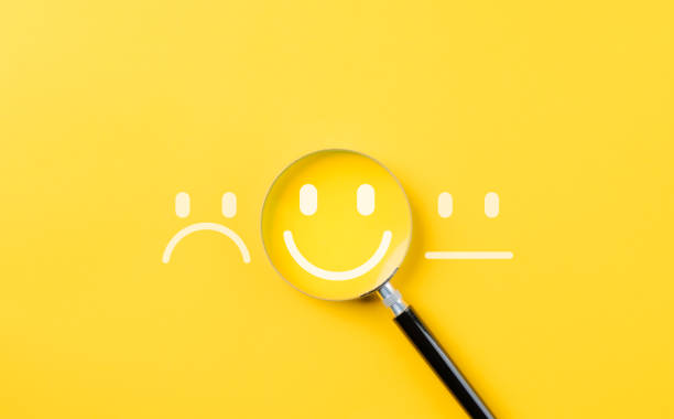 istock Customer review satisfaction feedback survey concept to gather insights and improve its services. A magnifying glass focuses on smile face among different feedback emoticons on yellow background 2177202512