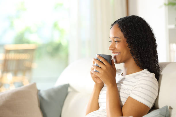 istock Happy black woman drinking coffee smiling at home 2177207196