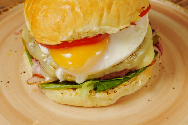 istock Breakfast burger features a perfectly fried egg, fresh tomatoes, and crispy lettuce layered with savory bacon and cheese 2177207671