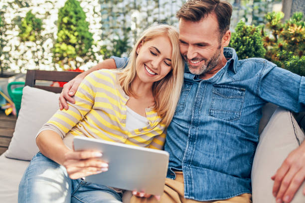 istock Adult couple on terrace using tablet on the sofa 2177210638